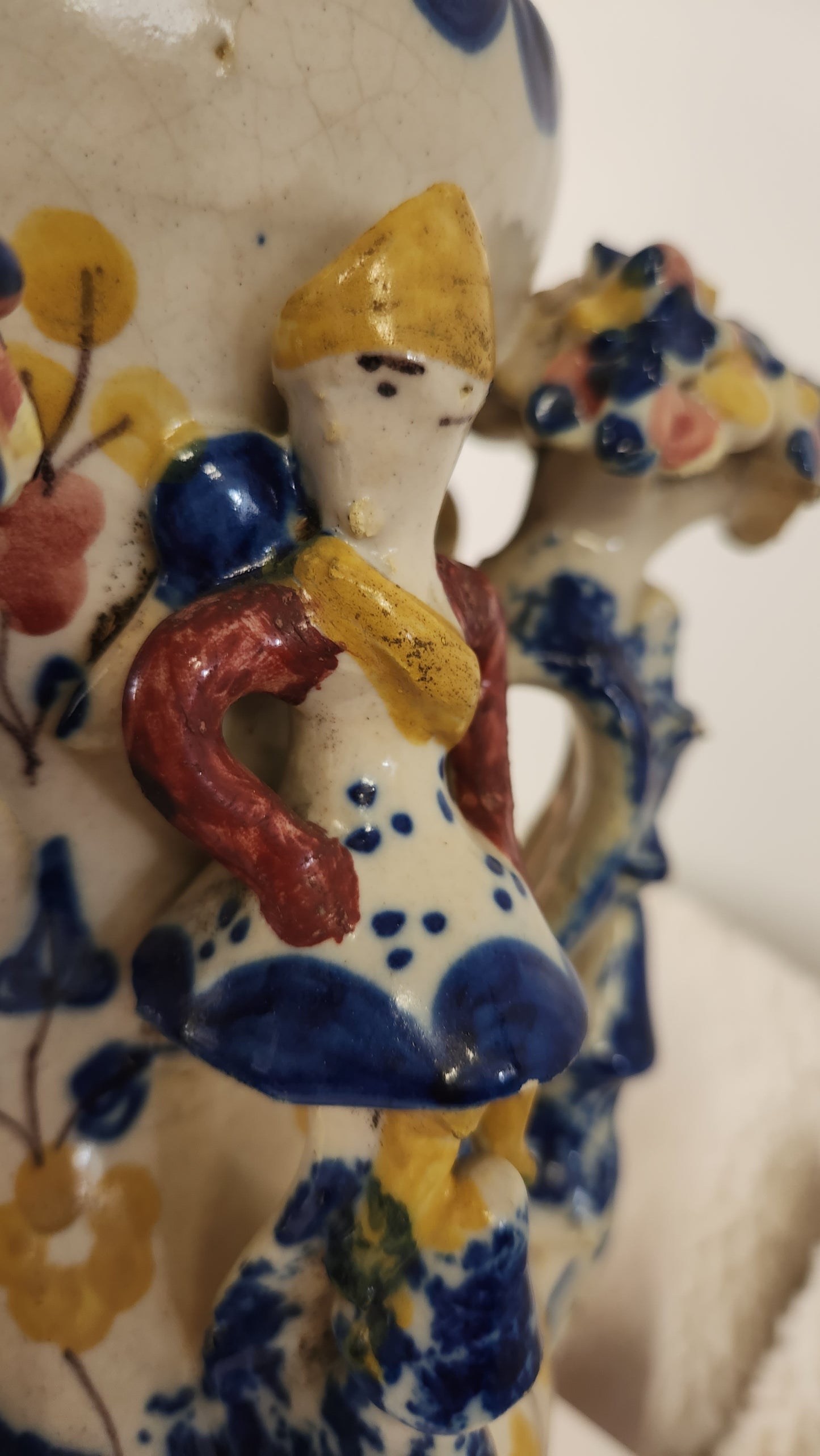 A close-up of a hand-painted ceramic figurine depicting a stylized French cowardly soldier dressed in a petticoat