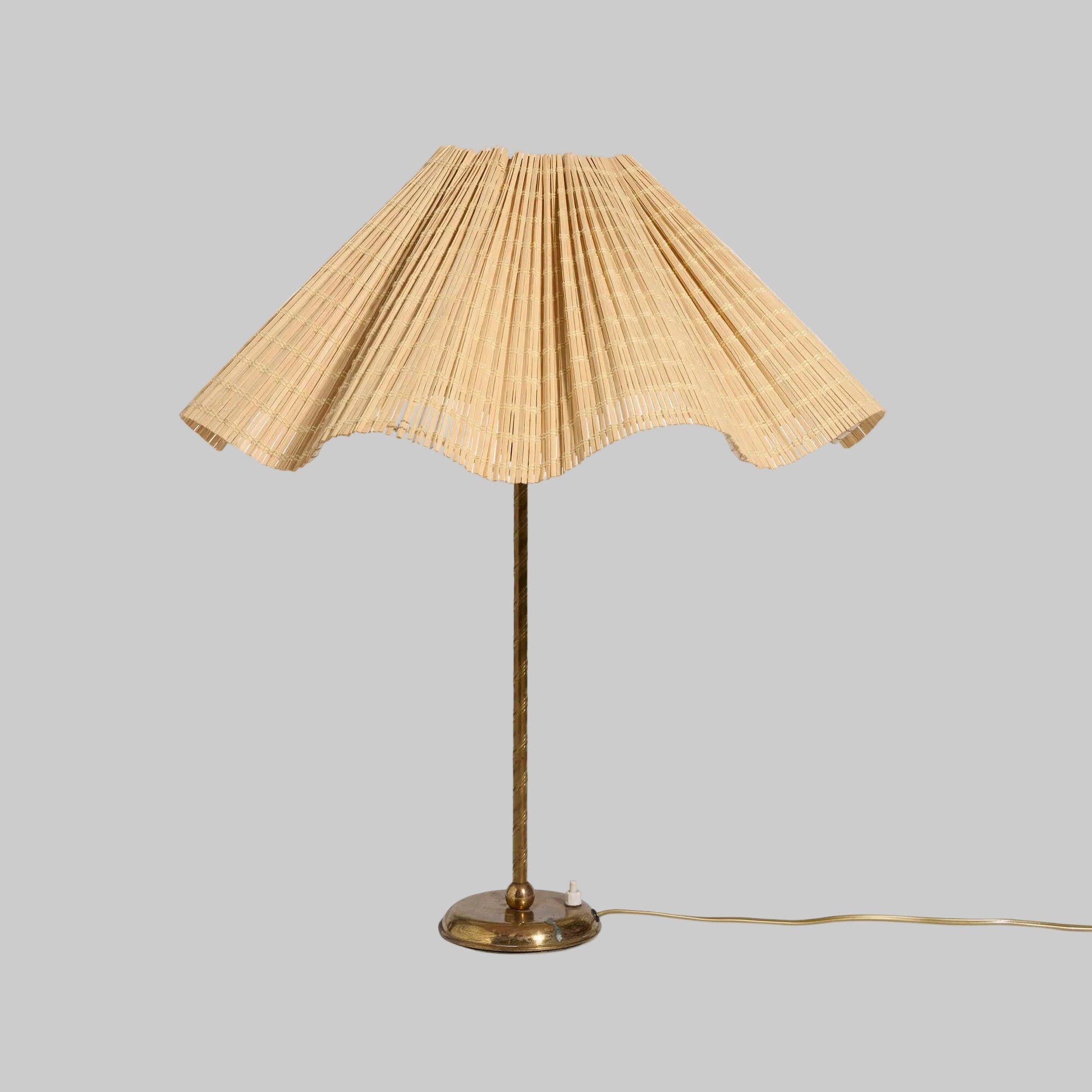 Table lamp with pleated beige shade on a white background