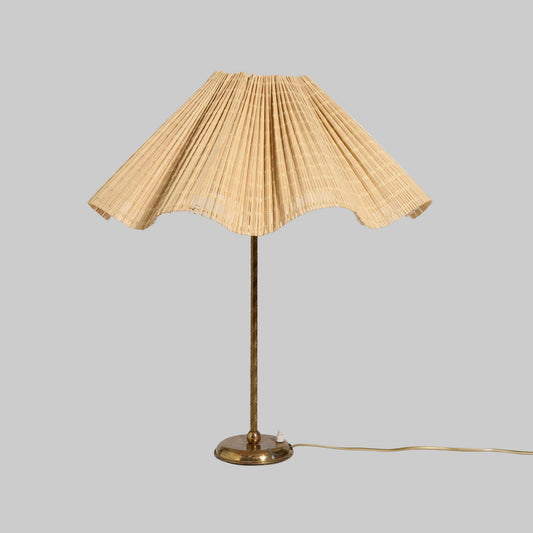 Table lamp with pleated beige shade on a white background