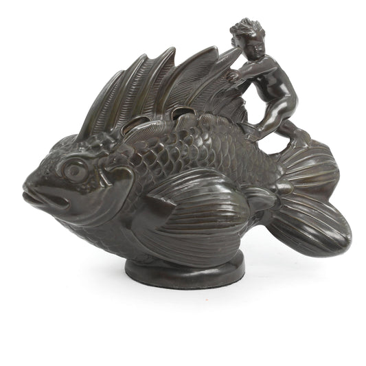 Bronze sculpture of a large fish with a small nude child riding on its back, displayed on a white background. The fish is also a vase for flowers.