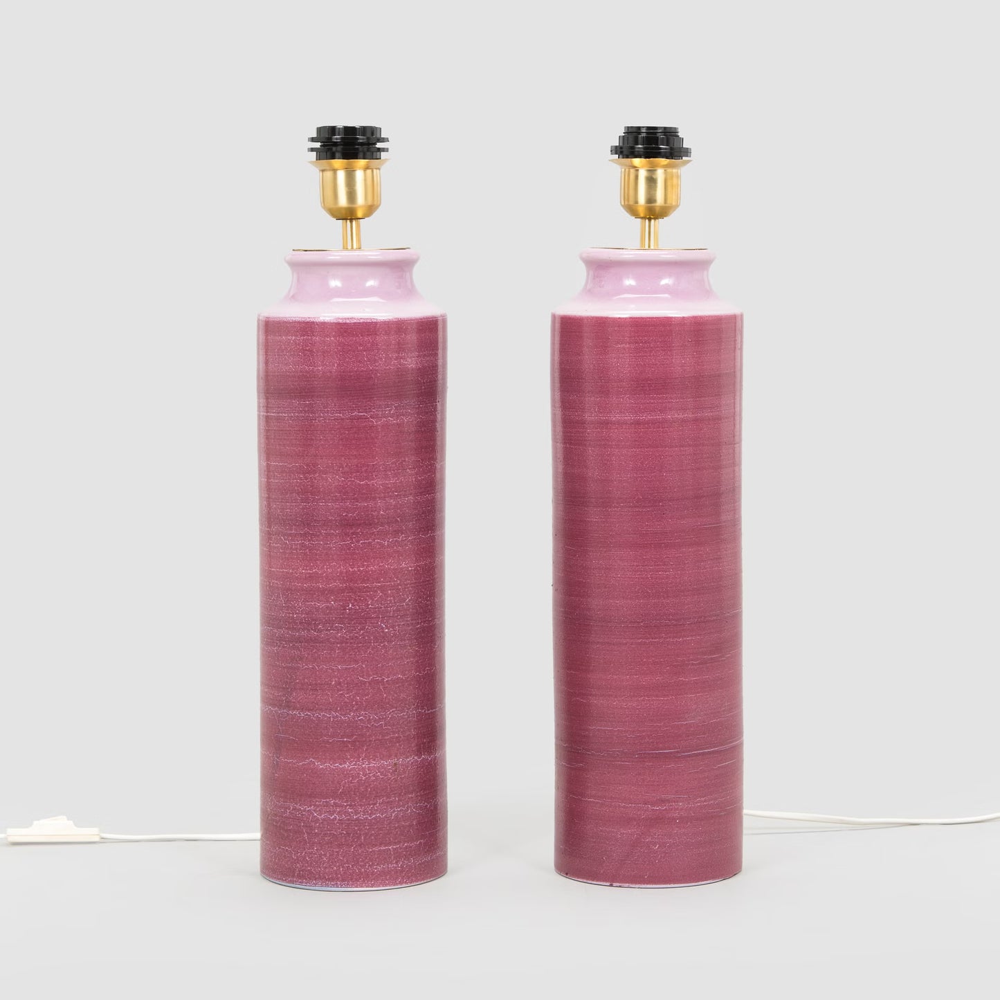 2 pink ceramic table lamps without shades, showing the brass fittings
