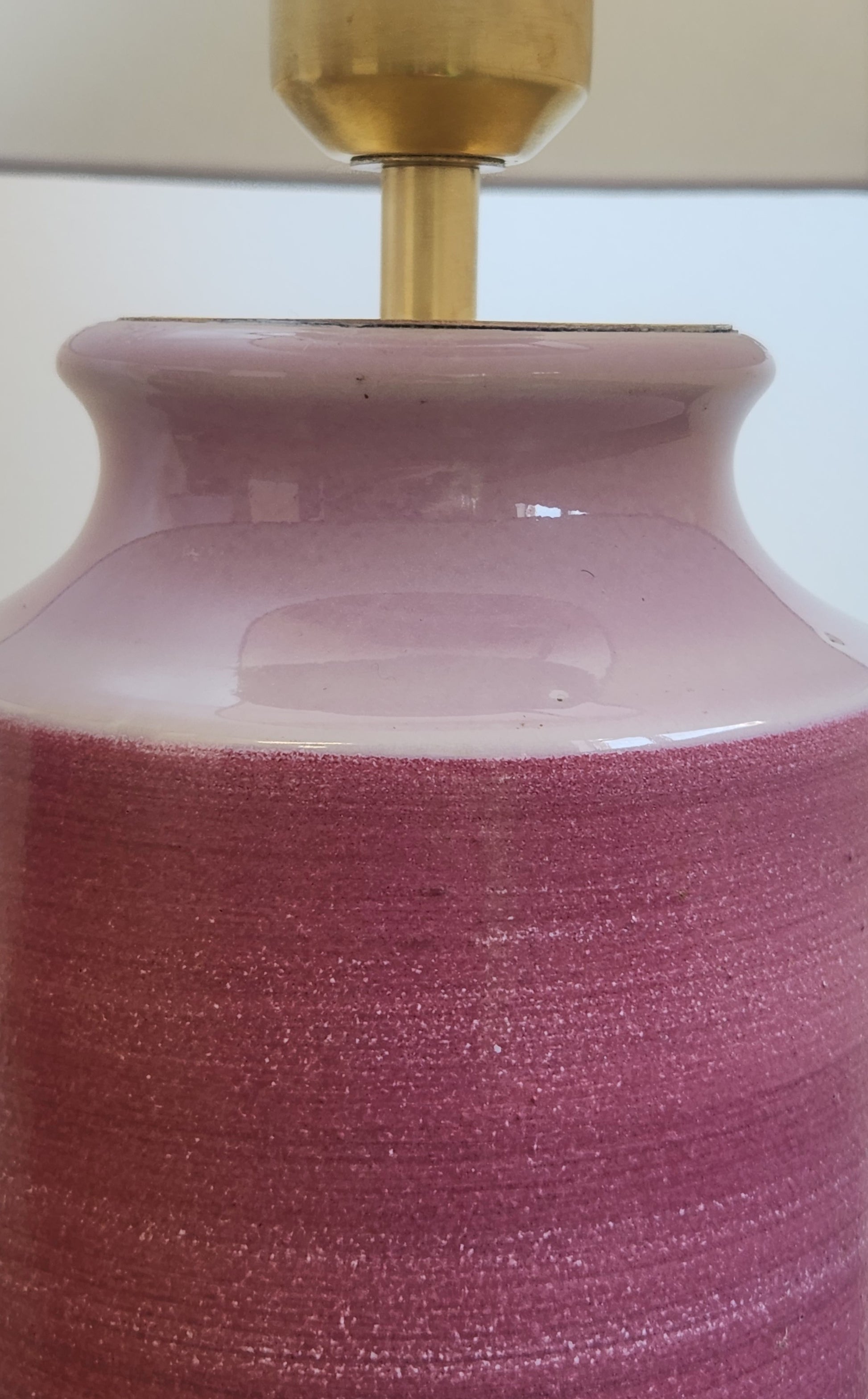 Close-up of a pink ceramic lamp base with a gold fixture.