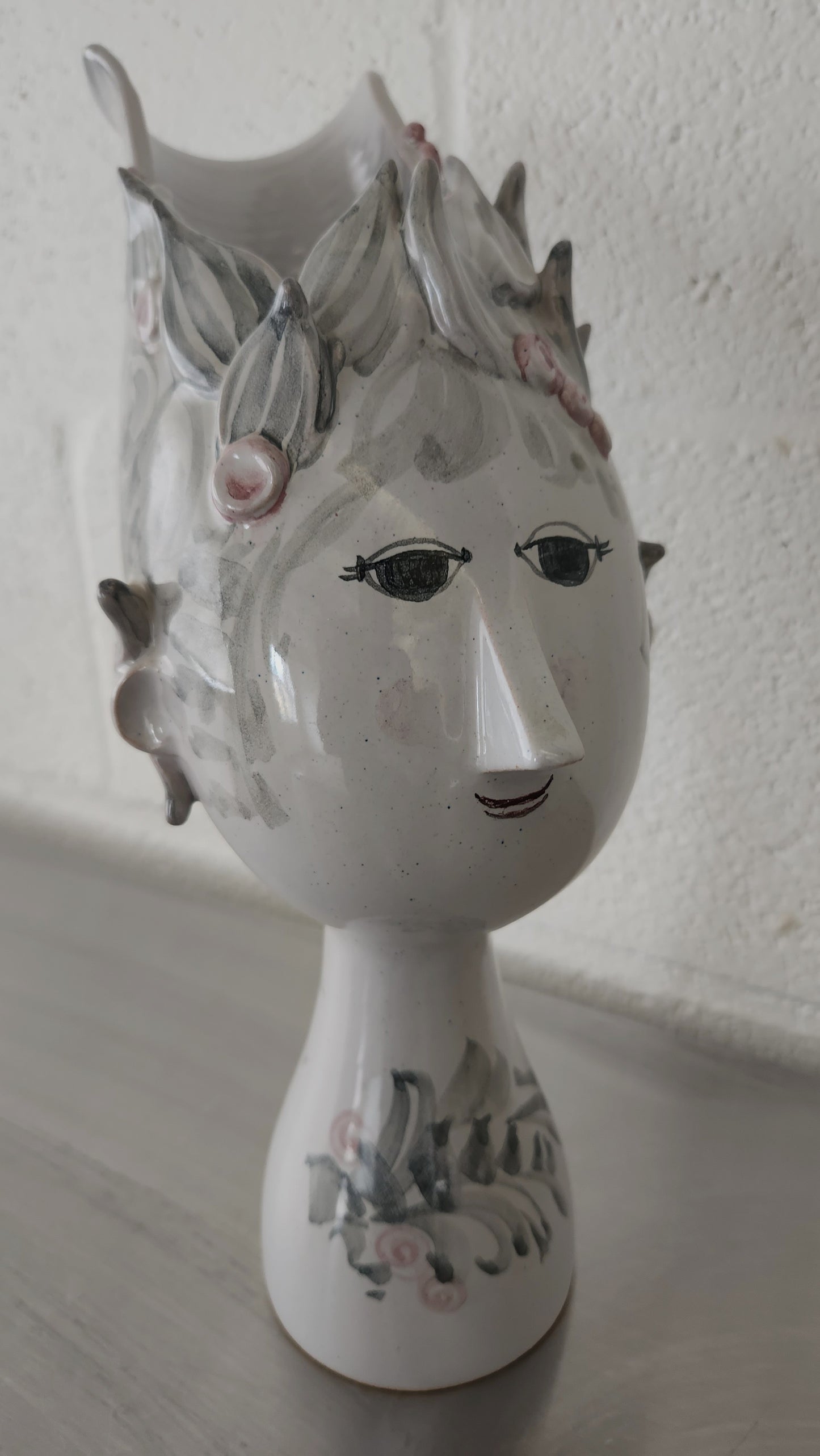 front view of vase with female face and floral hair