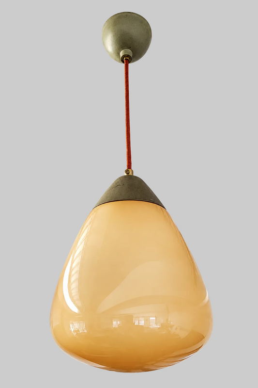 A vintage Orno pendant light with a teardrop-shaped frosted glass shade in a warm beige color, hanging from a dark metal cap and a brown cord against an industrial ceiling.