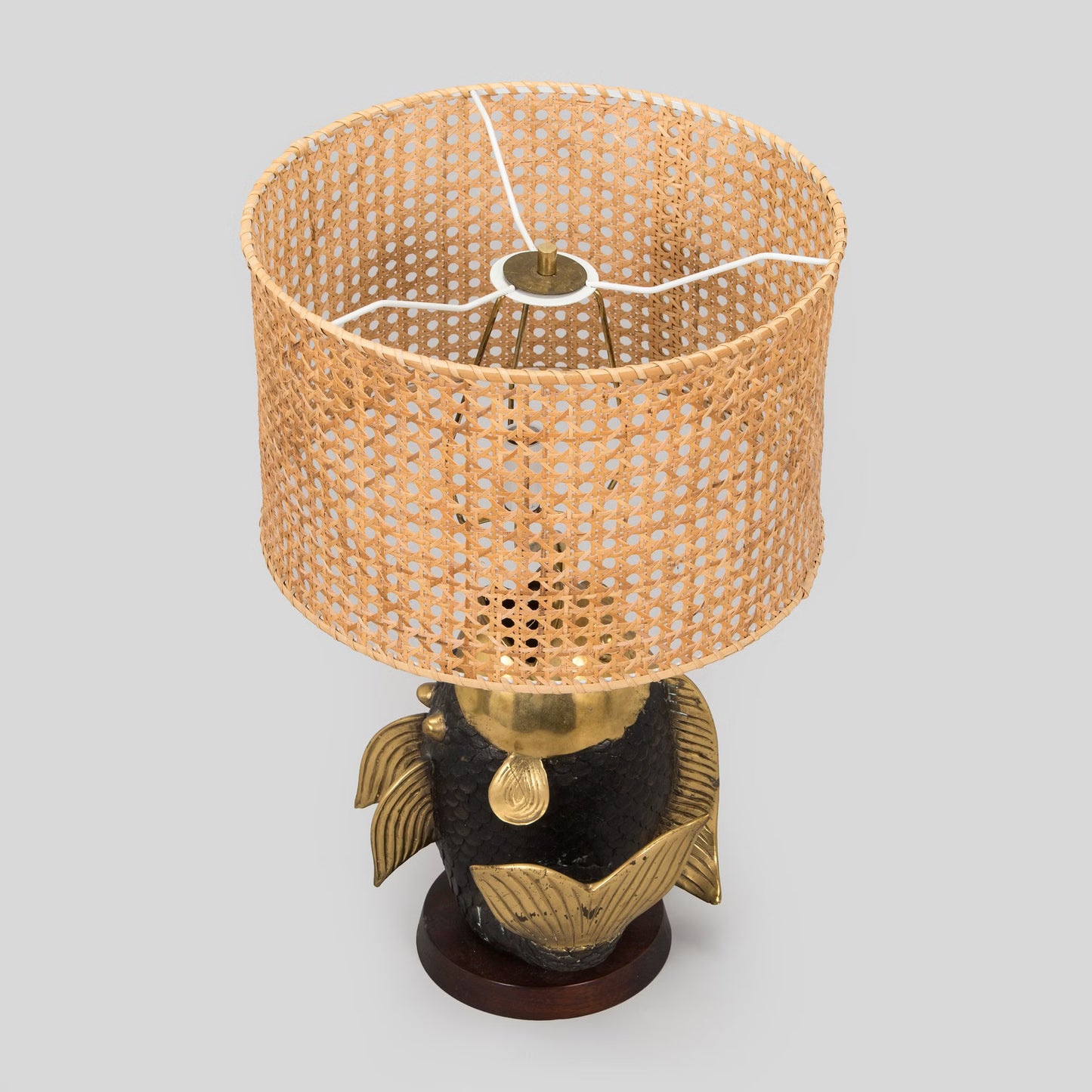 Decorative lamp with woven shade and fish-shaped base on a light gray background