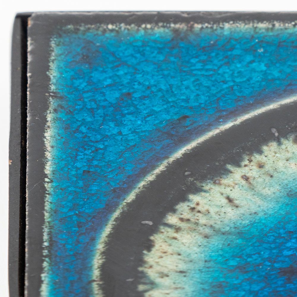 Close-up of a ceramic plate with blue and black glaze