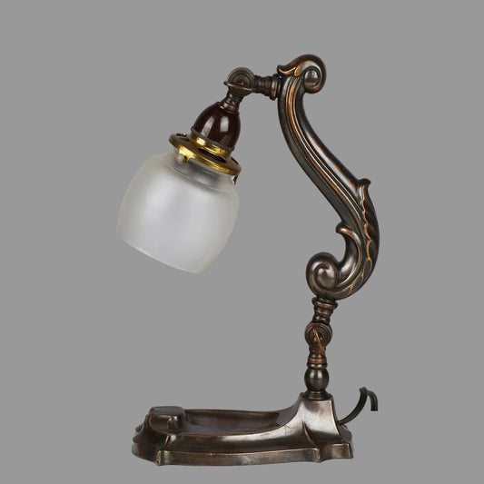 Vintage-style desk lamp with intricate design on a plain background
