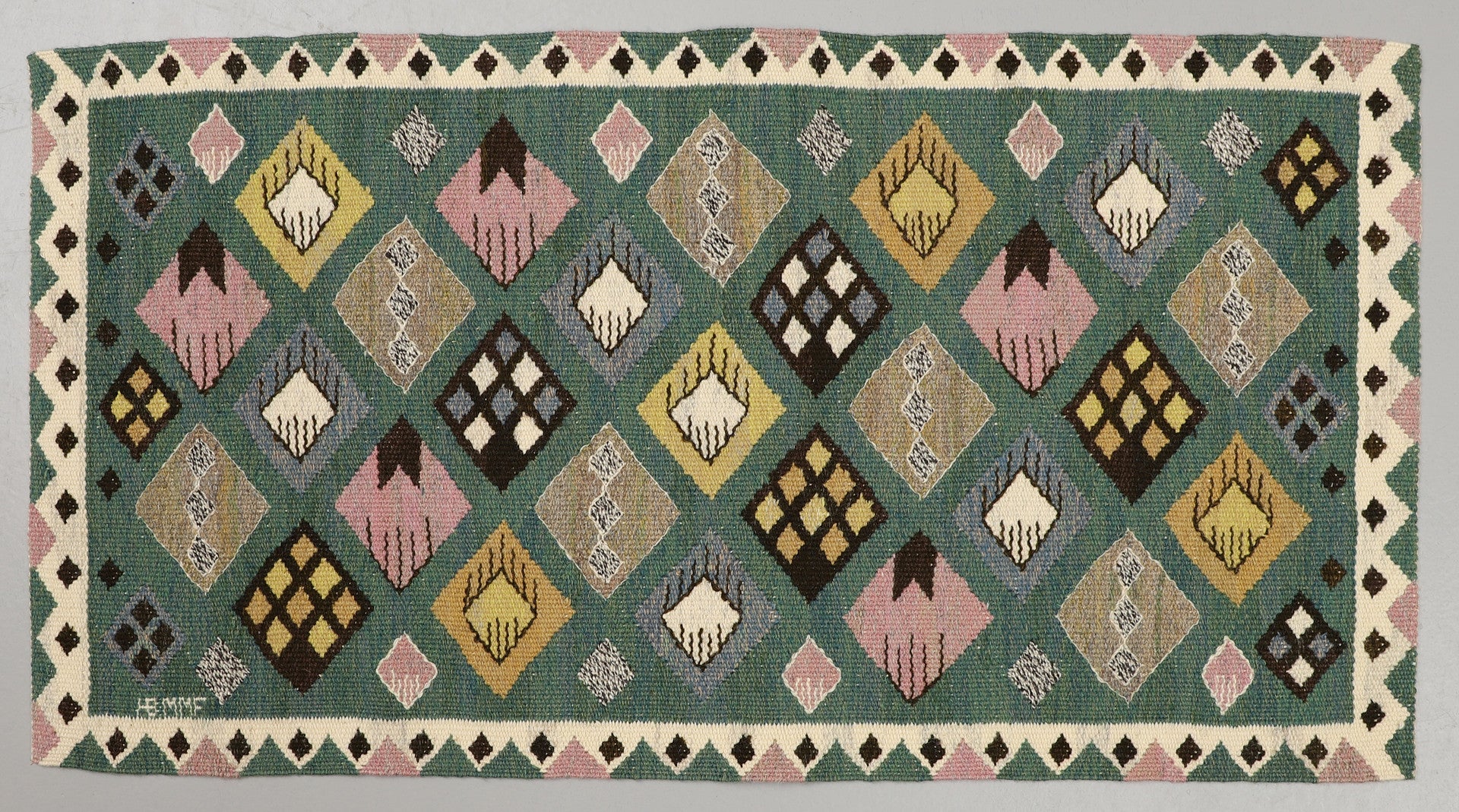 Decorative rug with geometric pattern on a green background