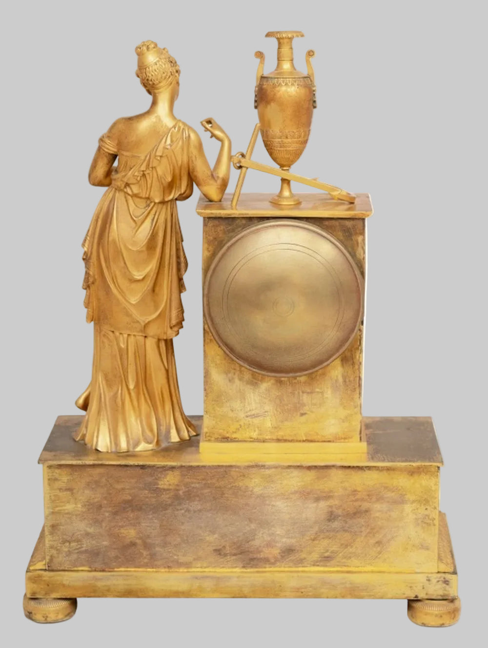 Decorative gold statue of a classical figure with an urn on a pedestal against a white background