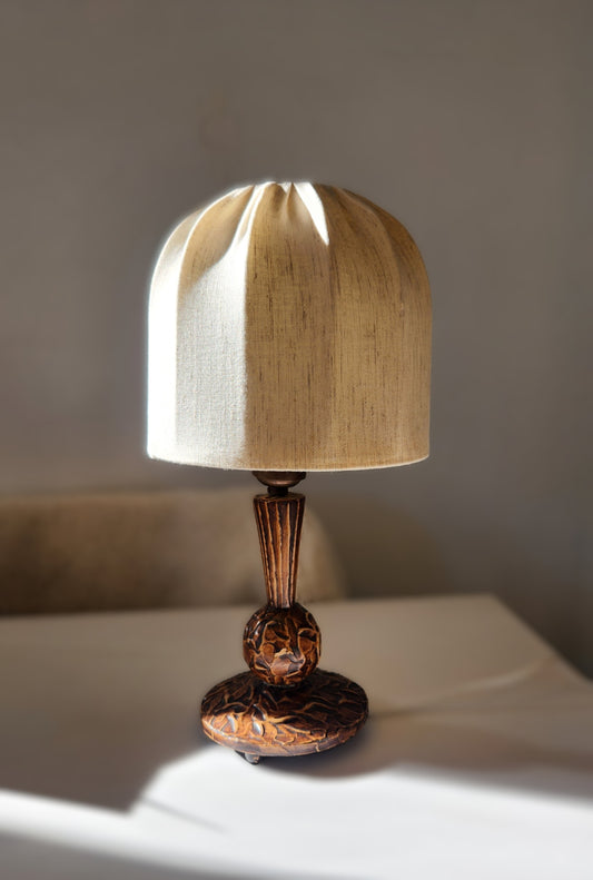 small vintage Swedish table lamp with wooden hand carved base and stem topped with a mushroom shaped linen lampshade, set on a white table
