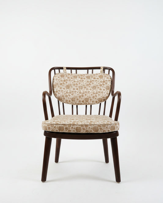 Chair with patterned cushion on a concrete floor and white wall background