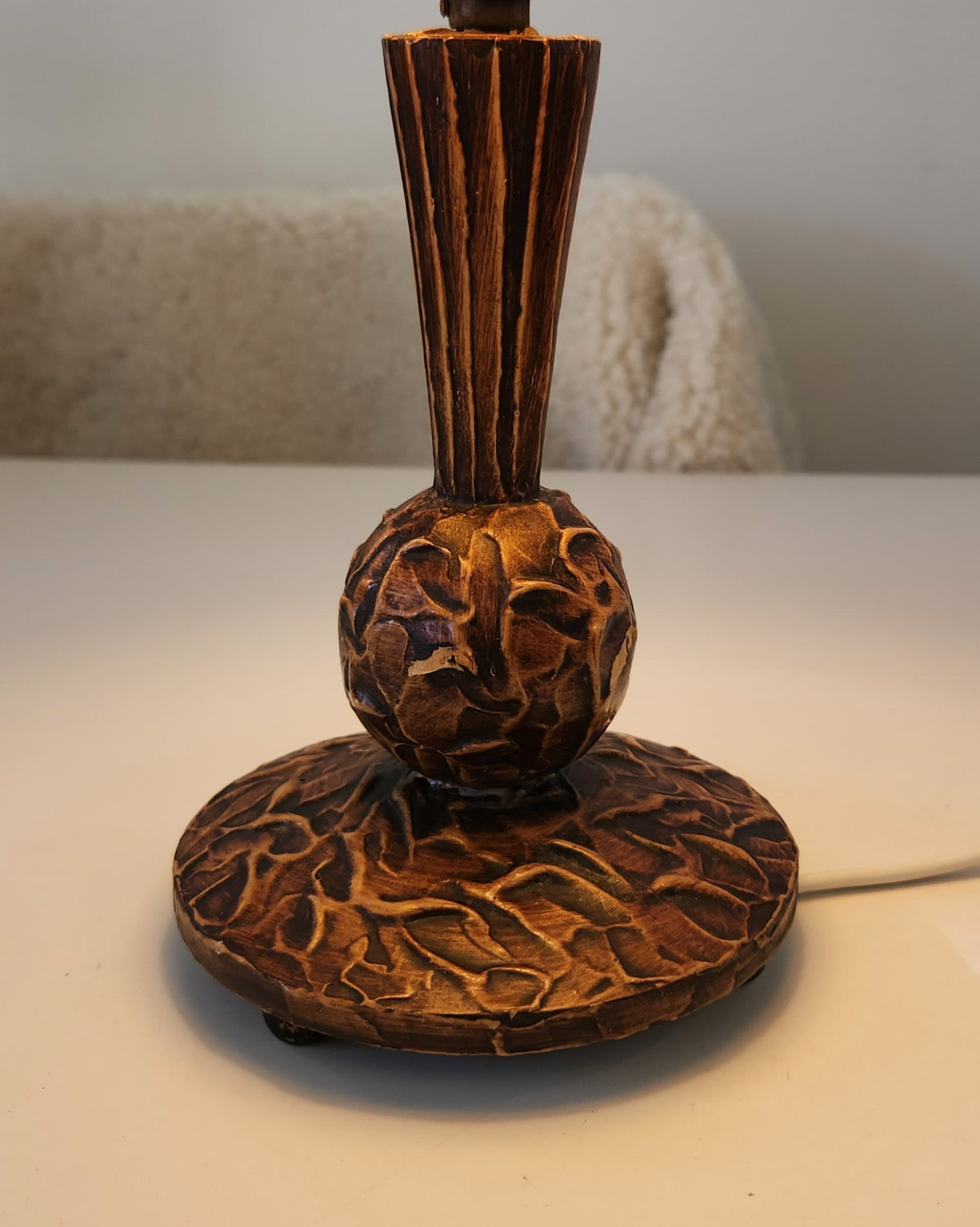 close up view of hand carved wooden lamp base and stem

