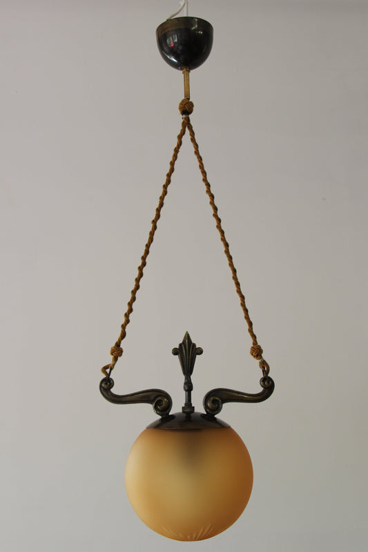 pendant lamp with decorative brass frame and sepia colored glass globe
